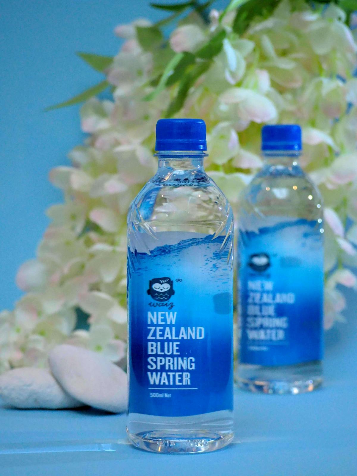 兩瓶500ml的Waiz紐西蘭藍泉礦泉水，背景是鮮花。